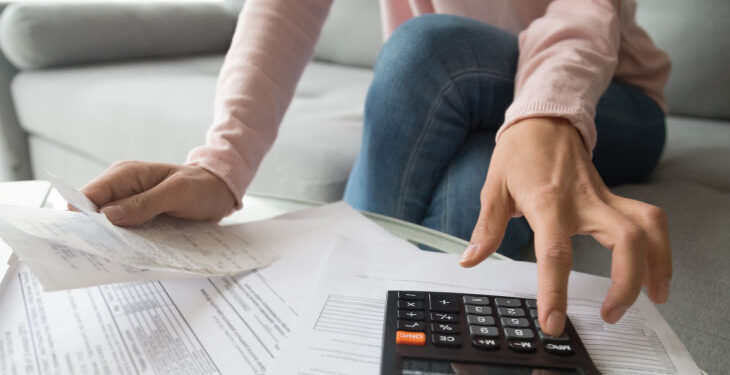 Person managing finances and improving credit habits using a monthly budget