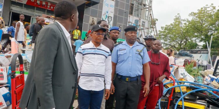 Deputy Governor Joel Salifu assessing fire damage at PEELINKS Electronics in Lokoja